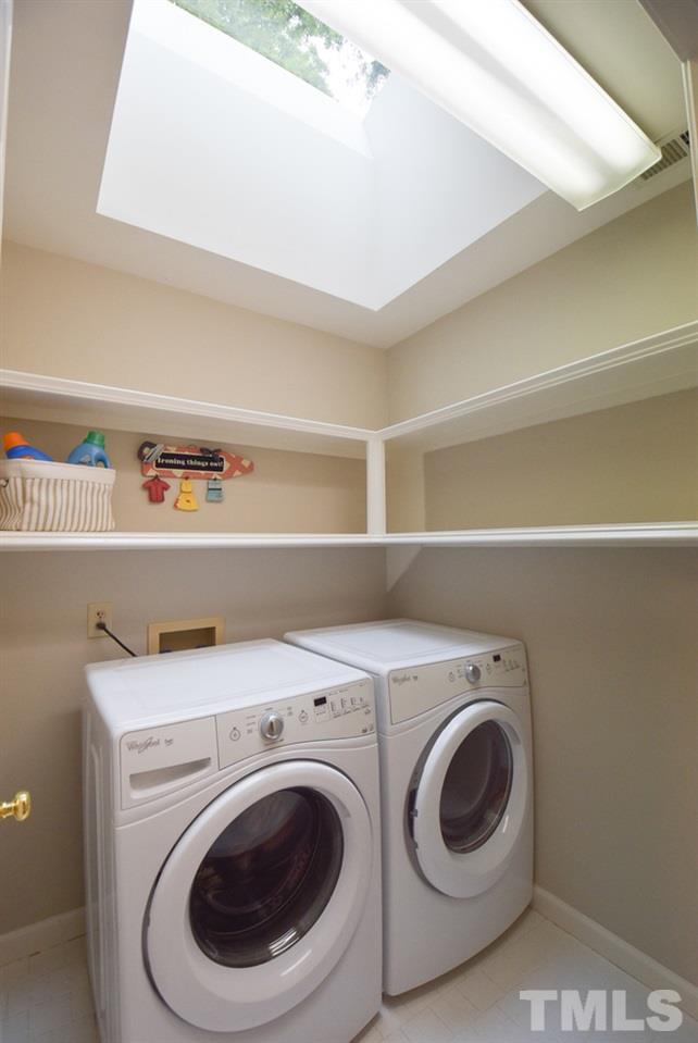9004 Enfield Court Raleigh, NC 27615 - Photo 23 of 30 2nd flr Laundry Rm w/skylight, wall shelving & neutral tile floor; across hall is lg hallway storage closet.