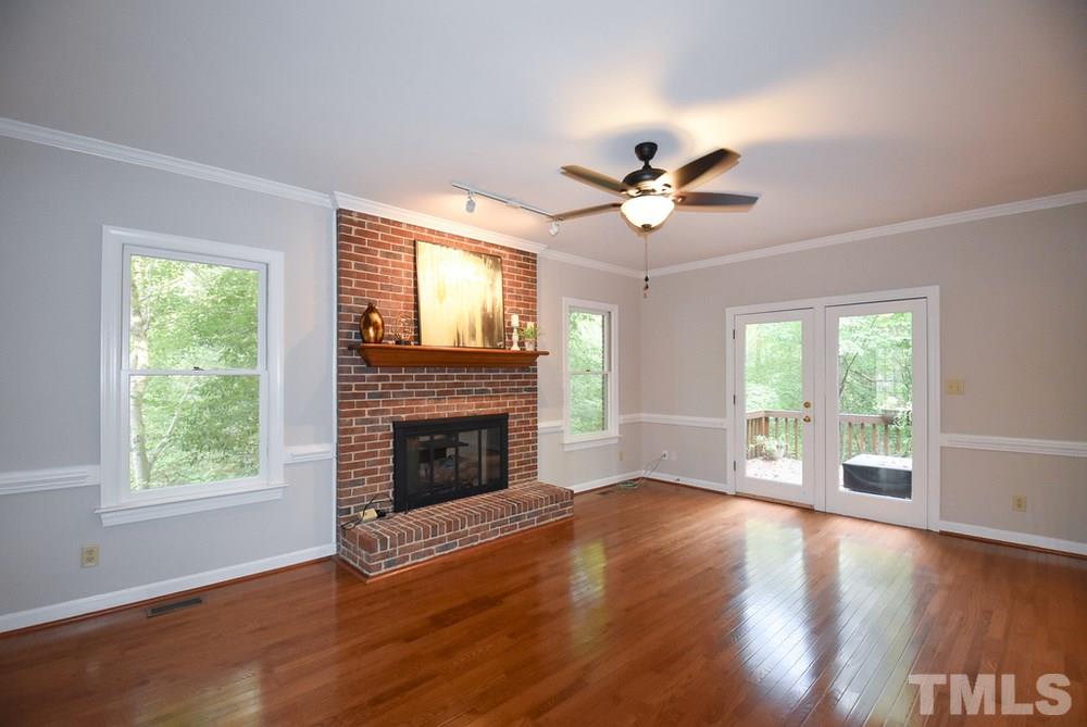 9004 Enfield Court Raleigh, NC 27615 - Photo 8 of 30 Big Family Rm w/brick gas log FP, hardwood flr, crown/chair rail molding, CF & glass door to Deck is open to the spacious Kitchen.