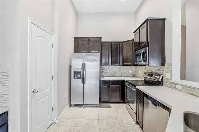 a kitchen with stainless steel appliances granite countertop a refrigerator sink and stove