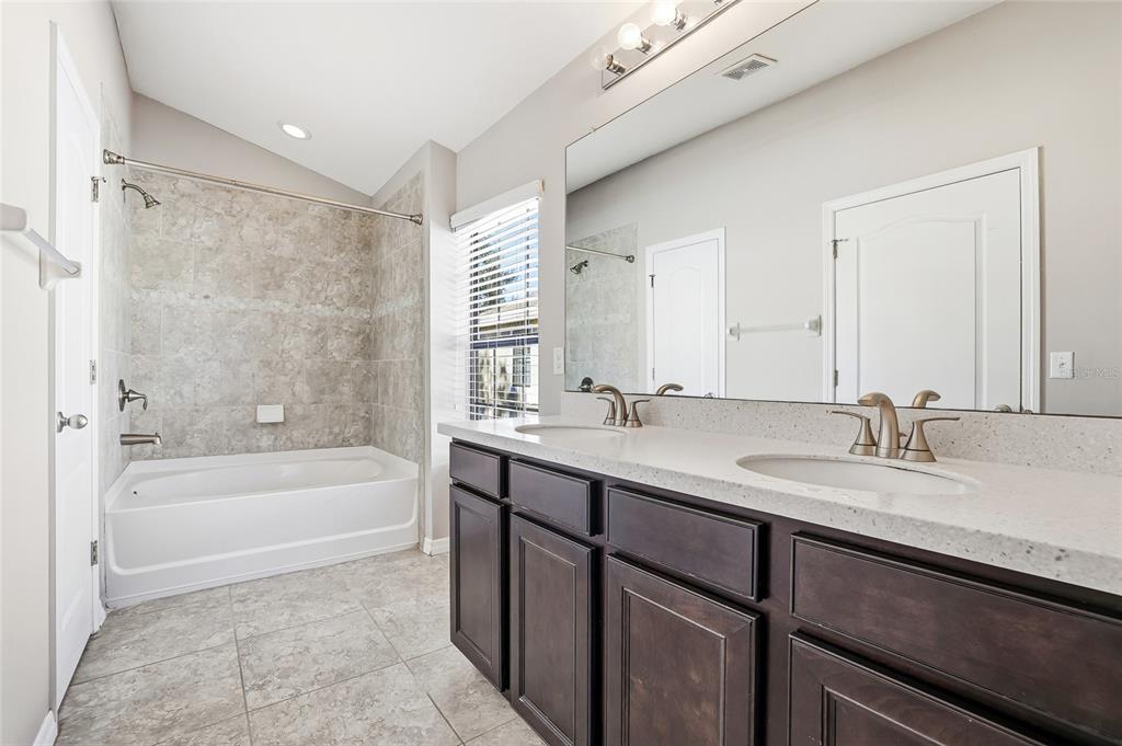5723 Kingletsound Lithia, FL 33547 - Photo 23 of 33 a bathroom with a tub sink double vanity granite and a bathtub