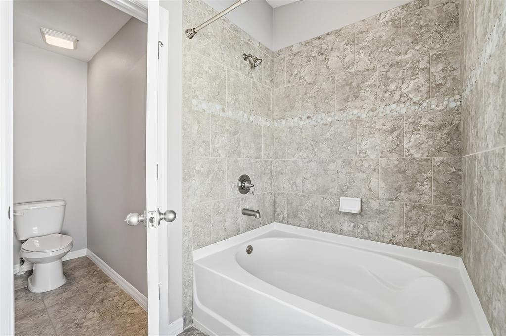 5723 Kingletsound Lithia, FL 33547 - Photo 24 of 33 a white bath tub sitting next to a toilet