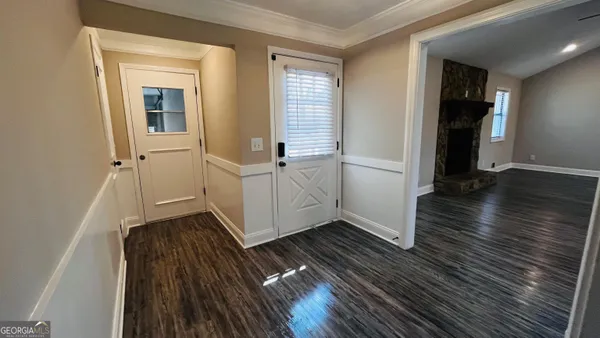 wooden floor with white walls and stairs