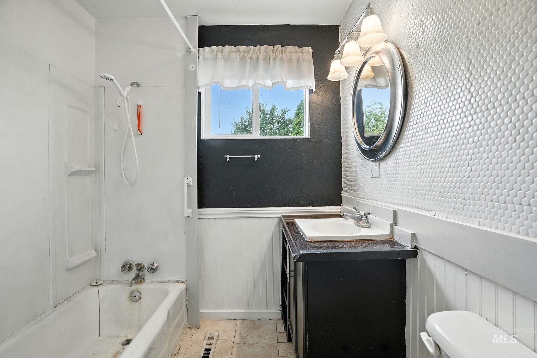 3506 10th Street Lewiston, ID 83501 - Photo 20 of 40 Bathroom featuring shower / tub combination, vanity, light tile patterned floors, and a wainscoted wall