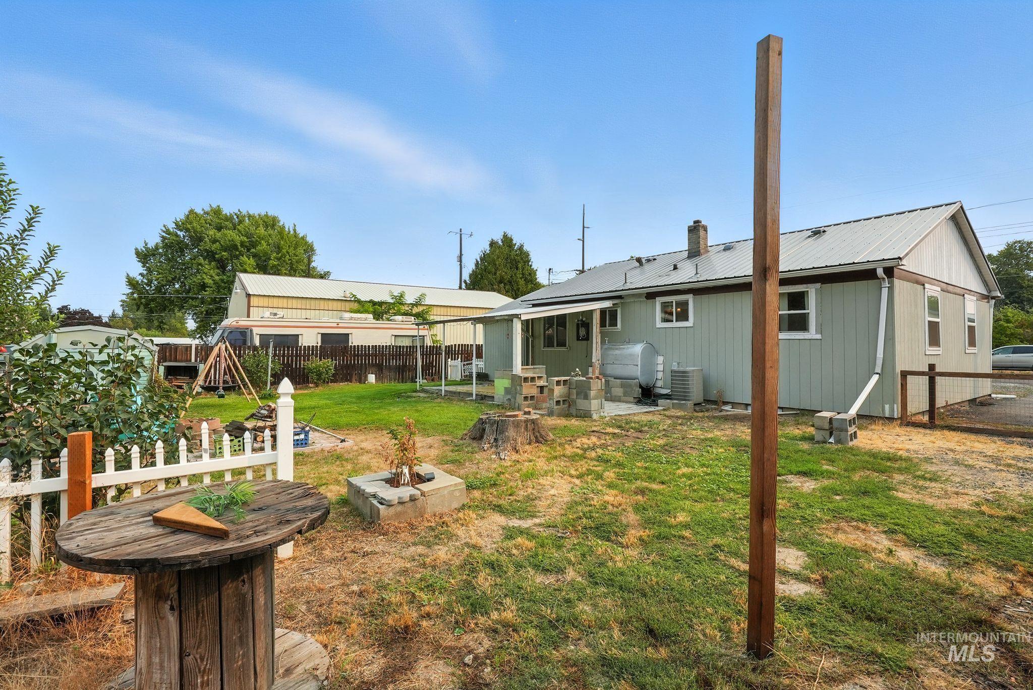 3506 10th Street Lewiston, ID 83501 - Photo 40 of 40 Back of house with a patio area, a metal roof, a fenced backyard, and a chimney