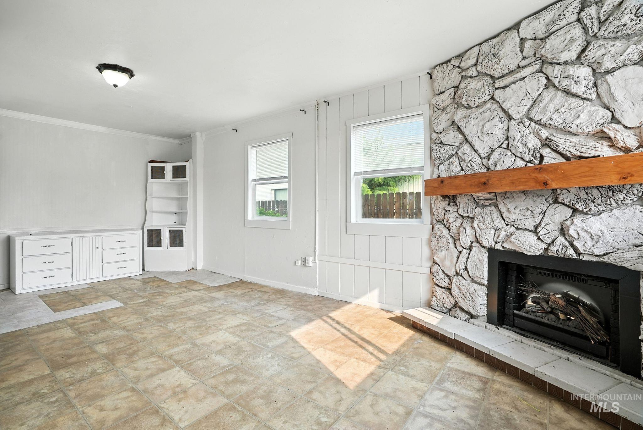 3506 10th Street Lewiston, ID 83501 - Photo 9 of 40 Unfurnished living room with a stone fireplace and crown molding