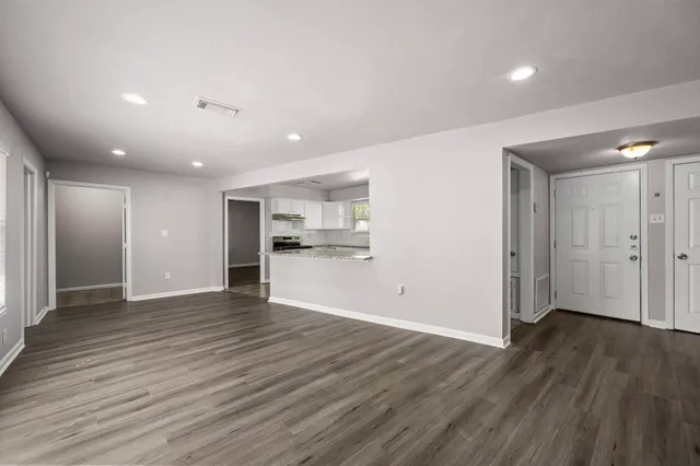 a view of empty room with wooden floor