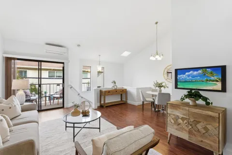 a living room with furniture kitchen view and a large window