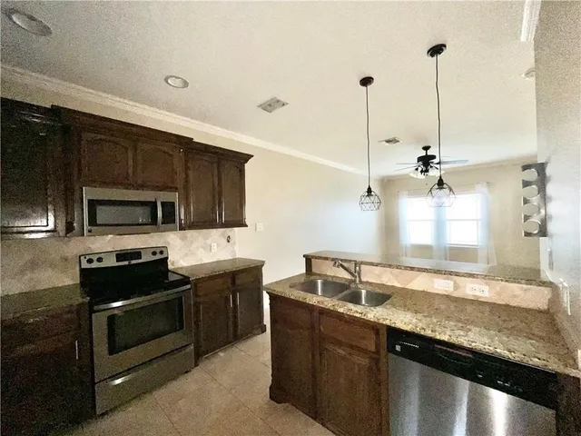 a kitchen with stainless steel appliances granite countertop a sink a stove and a microwave oven