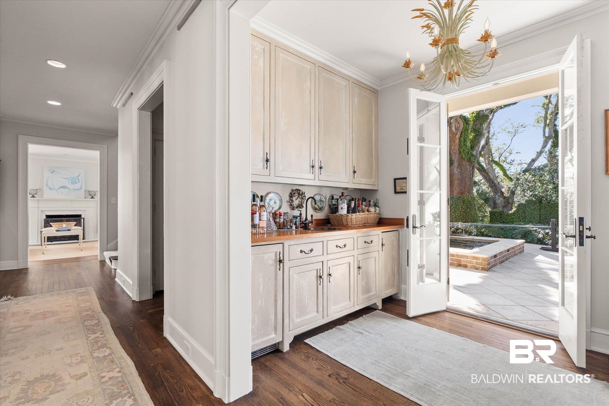 2256 De Leon Avenue Mobile, AL 36607 - Photo 6 of 61 Indoor bar with ornamental molding, dark wood finished floors, a fireplace, wooden counters, and hanging lights