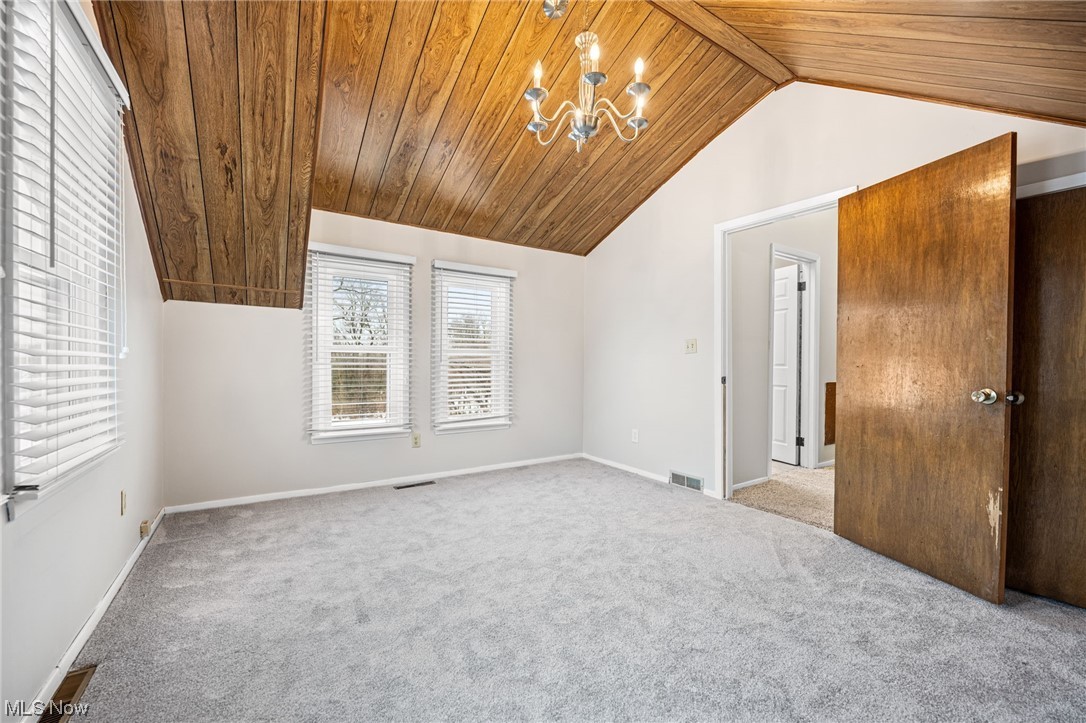 2986 Worrell Road Willoughby, OH 44094 - Photo 24 of 36 Carpeted spare room with a chandelier, wooden ceiling, and vaulted ceiling