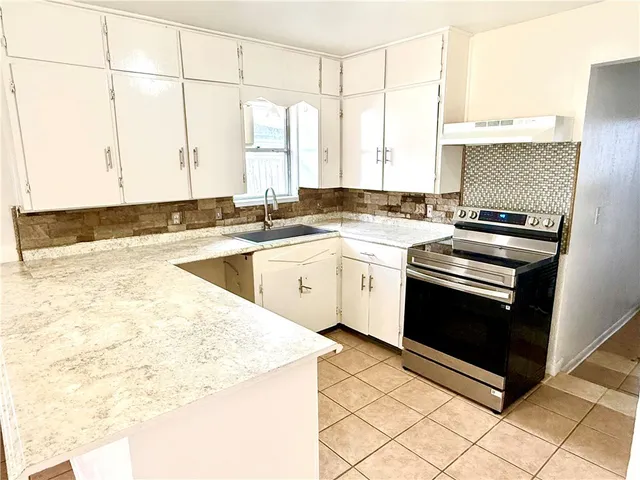 a kitchen with a stove a sink and a microwave