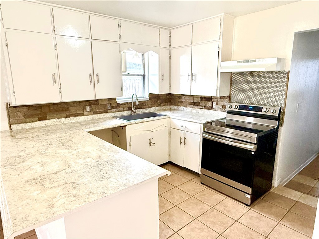 359 6th Street Somerville, TX 77879 - Photo 5 of 17 a kitchen with a stove a sink and a microwave