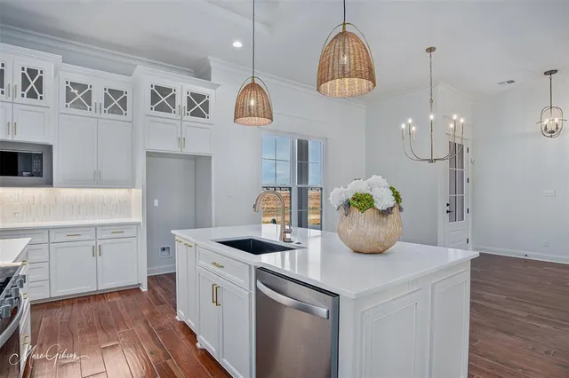 a kitchen with cabinets and wooden floor