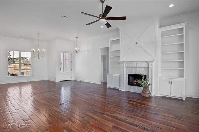 a view of empty room with a fireplace and wooden floor