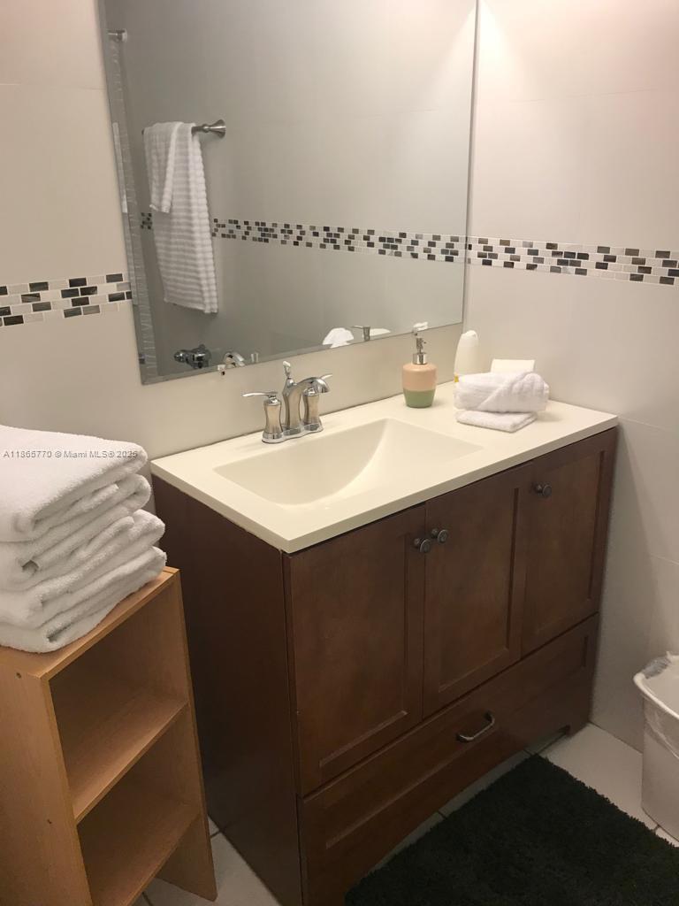 26 Diplomat Parkway, Unit 2233 Hallandale Beach, FL 33009 - Photo 2 of 7 a bathroom with a sink and a mirror