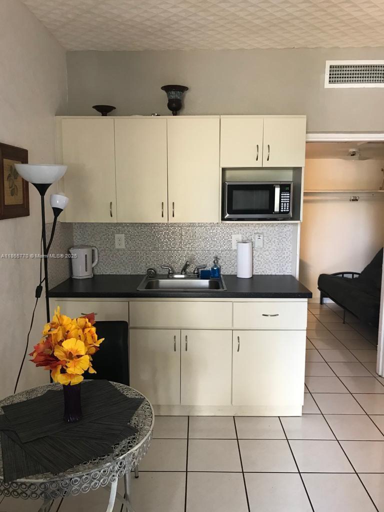 26 Diplomat Parkway, Unit 2233 Hallandale Beach, FL 33009 - Photo 6 of 7 a kitchen with stainless steel appliances a stove a microwave and cabinets
