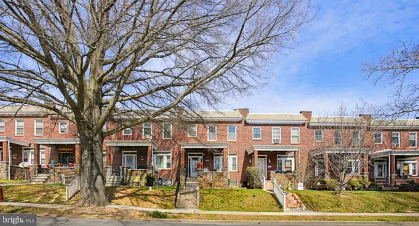 a front view of a building with large trees