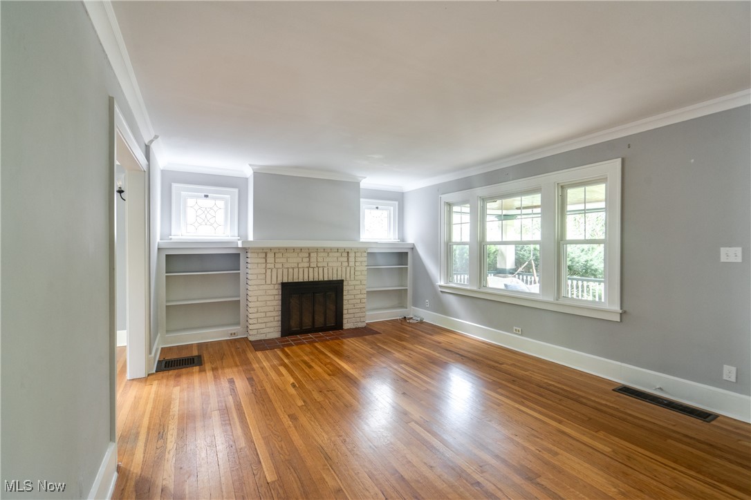 3130 Corydon Road Cleveland, OH 44118 - Photo 18 of 44 Unfurnished living room featuring a wealth of natural light, a fireplace, and hardwood / wood-style floors