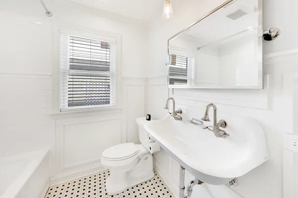 a bathroom with a sink a toilet and a mirror