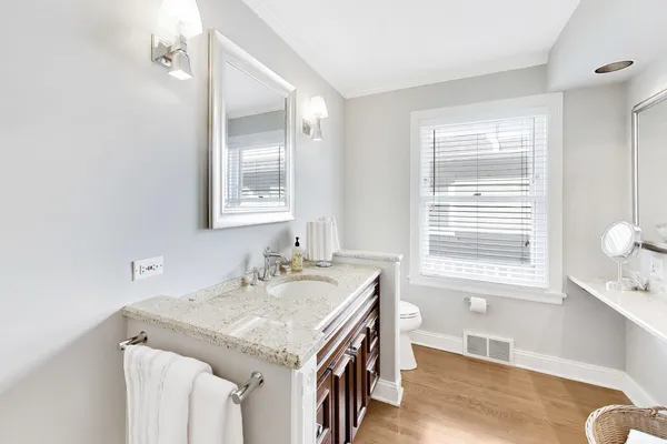 a bathroom with a granite countertop sink a mirror and a window