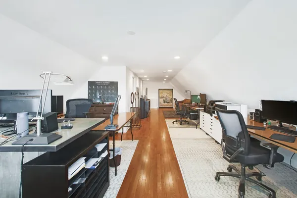 a view of a workspace with furniture and wooden floor