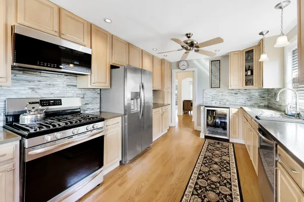 a kitchen with stainless steel appliances a stove a sink and a microwave
