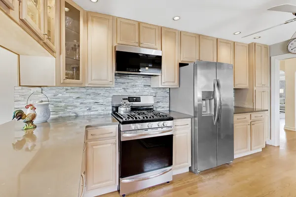 a kitchen with stainless steel appliances a stove a microwave and a sink