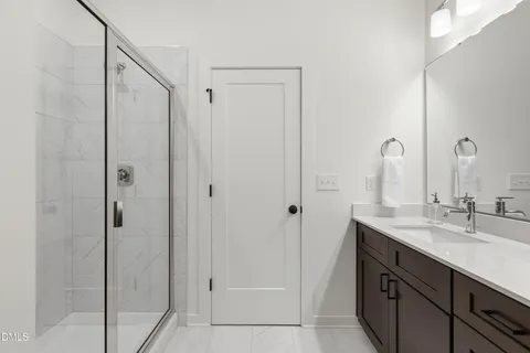 a en suite bathroom with a granite countertop sink and a mirror