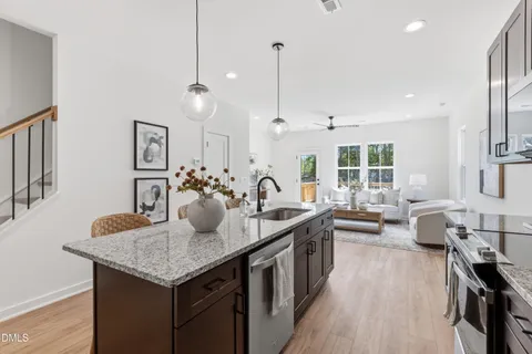 a kitchen with kitchen island granite countertop a sink counter and chairs