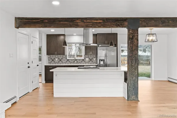 a kitchen with stainless steel appliances granite countertop a stove and a wooden floors