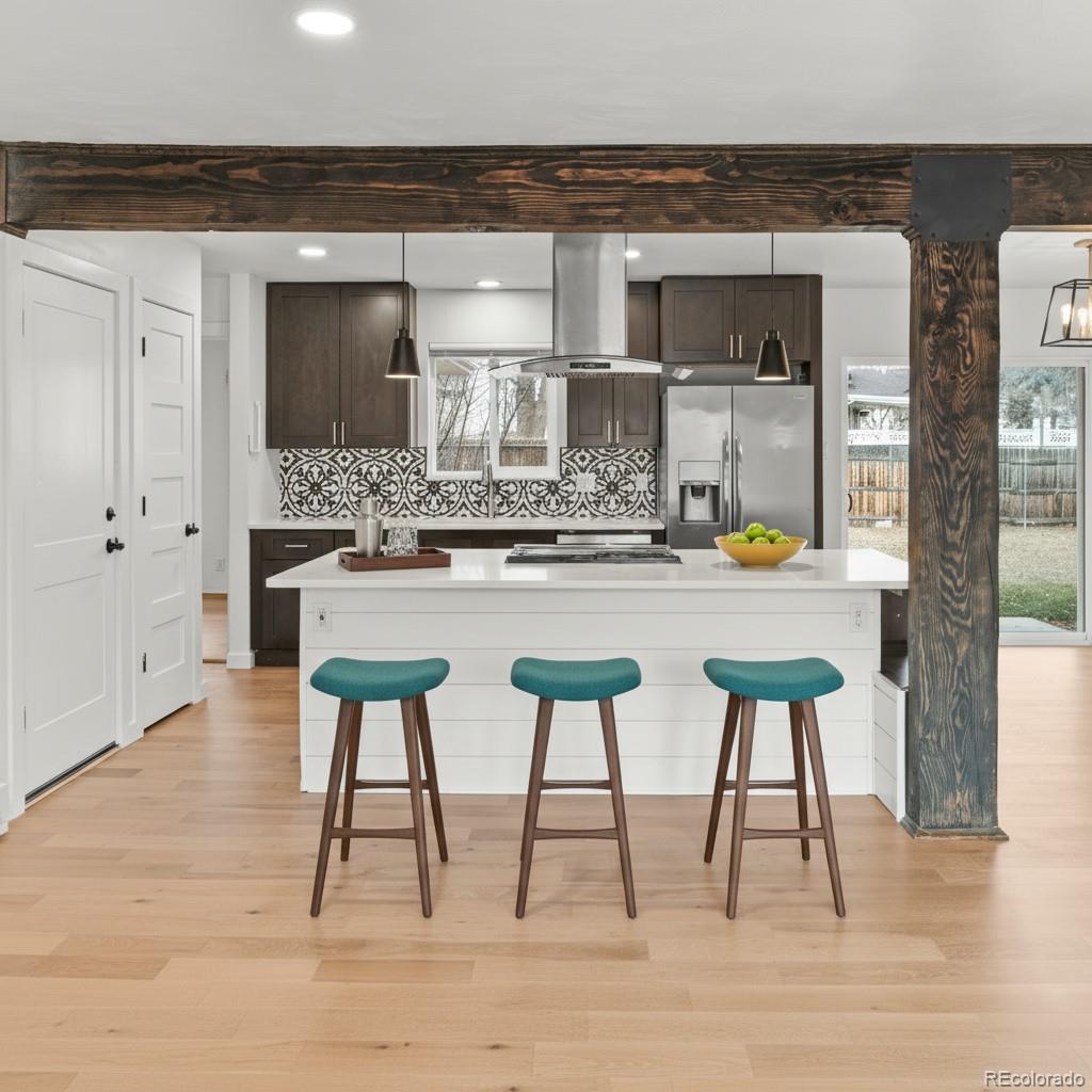 1440 Northwestern Road Longmont, CO 80503 - Photo 16 of 41 a kitchen with stainless steel appliances kitchen island granite countertop a table chairs in it and wooden floor