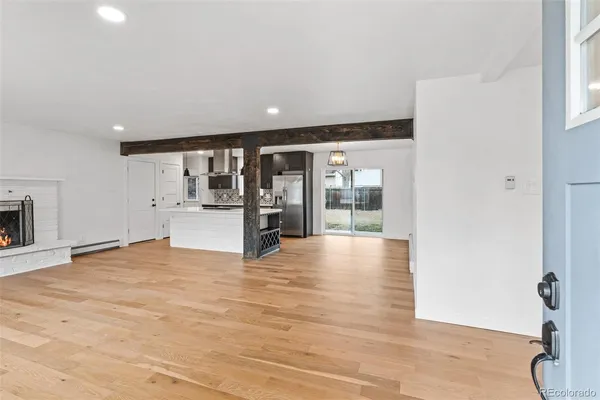 a view of an empty room with a window and fire place
