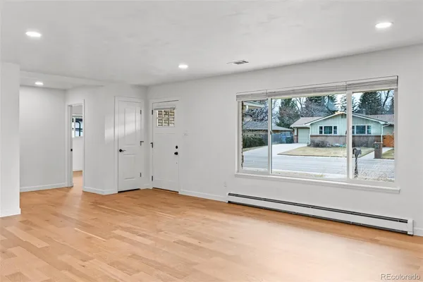 a view of an empty room with a window and fireplace