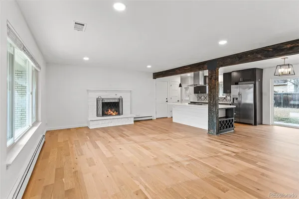 a kitchen with stainless steel appliances kitchen island granite countertop a table chairs in it and wooden floor