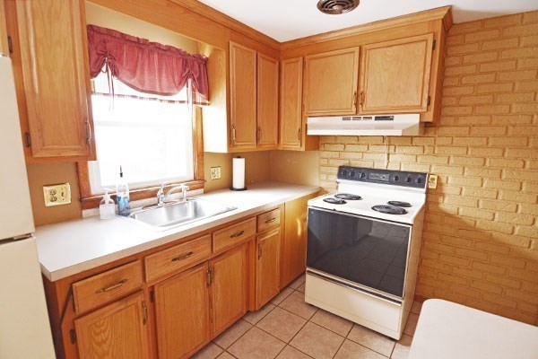 21 Hadley Street Springfield, MA 01118 - Photo 4 of 34 a kitchen with stainless steel appliances a stove a sink and a microwave
