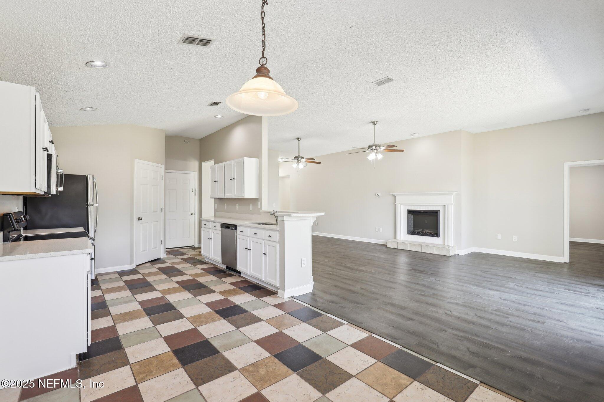 86123 Red Holly Place Yulee, FL 32097 - Photo 13 of 36 a kitchen with stainless steel appliances granite countertop a sink a stove a refrigerator and cabinets