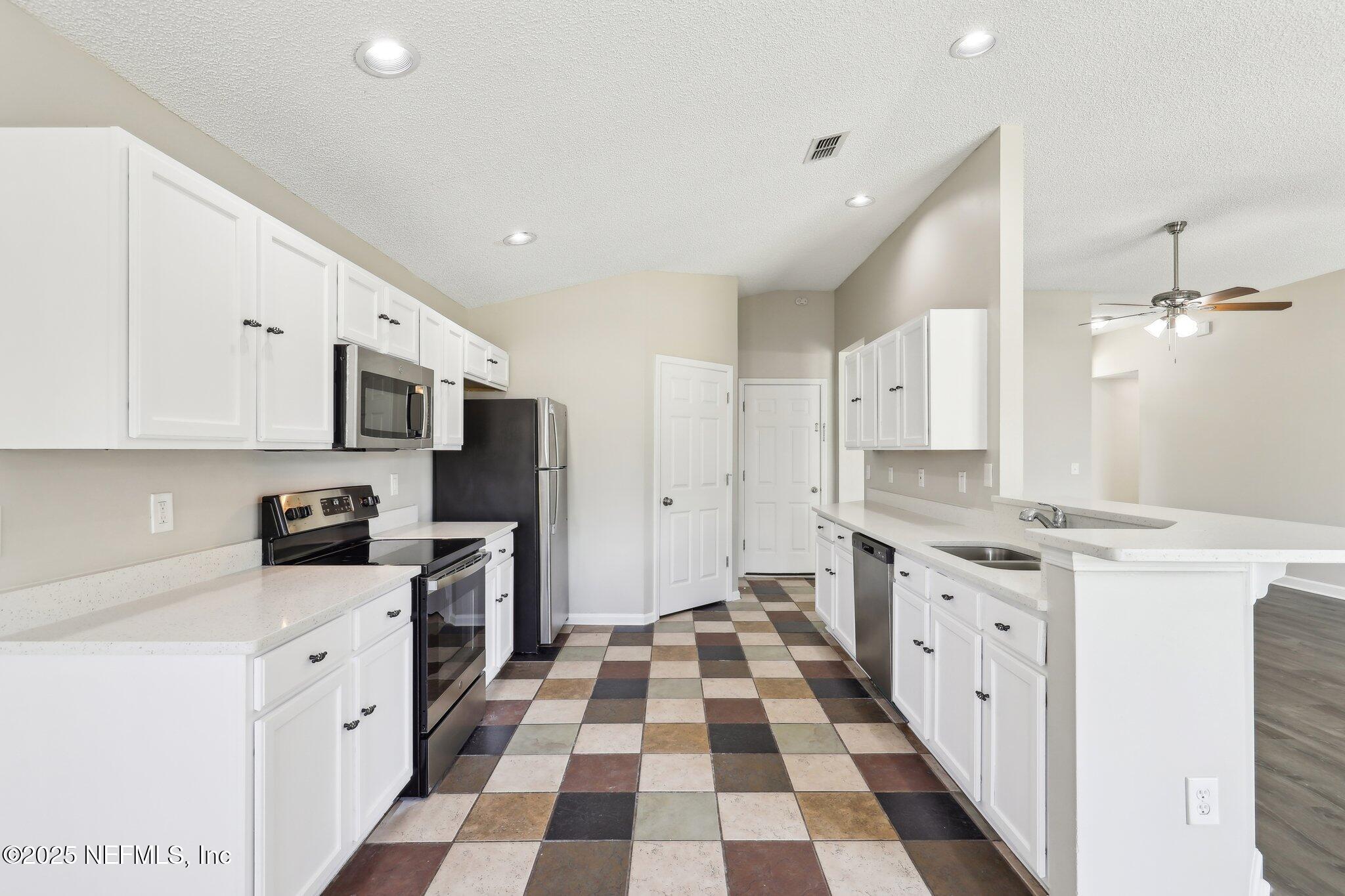 86123 Red Holly Place Yulee, FL 32097 - Photo 14 of 36 a kitchen with stainless steel appliances granite countertop a stove and a sink