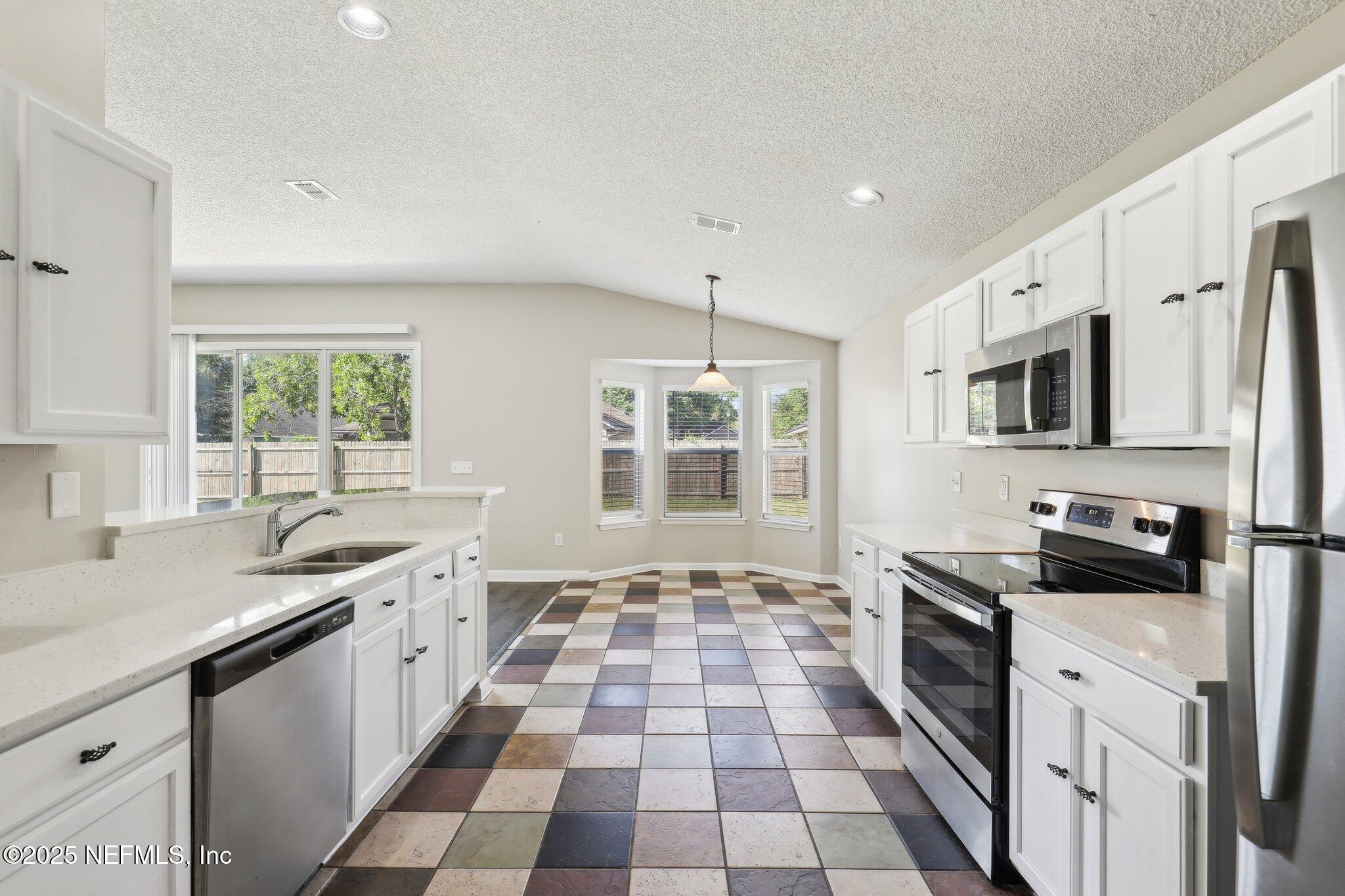86123 Red Holly Place Yulee, FL 32097 - Photo 17 of 36 a kitchen with stainless steel appliances granite countertop a stove a sink and a granite counter tops