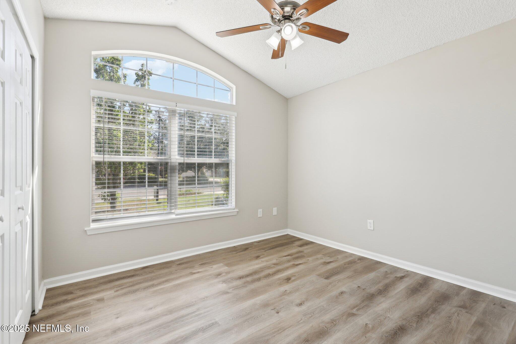 86123 Red Holly Place Yulee, FL 32097 - Photo 19 of 36 an empty room with wooden floor fan and windows