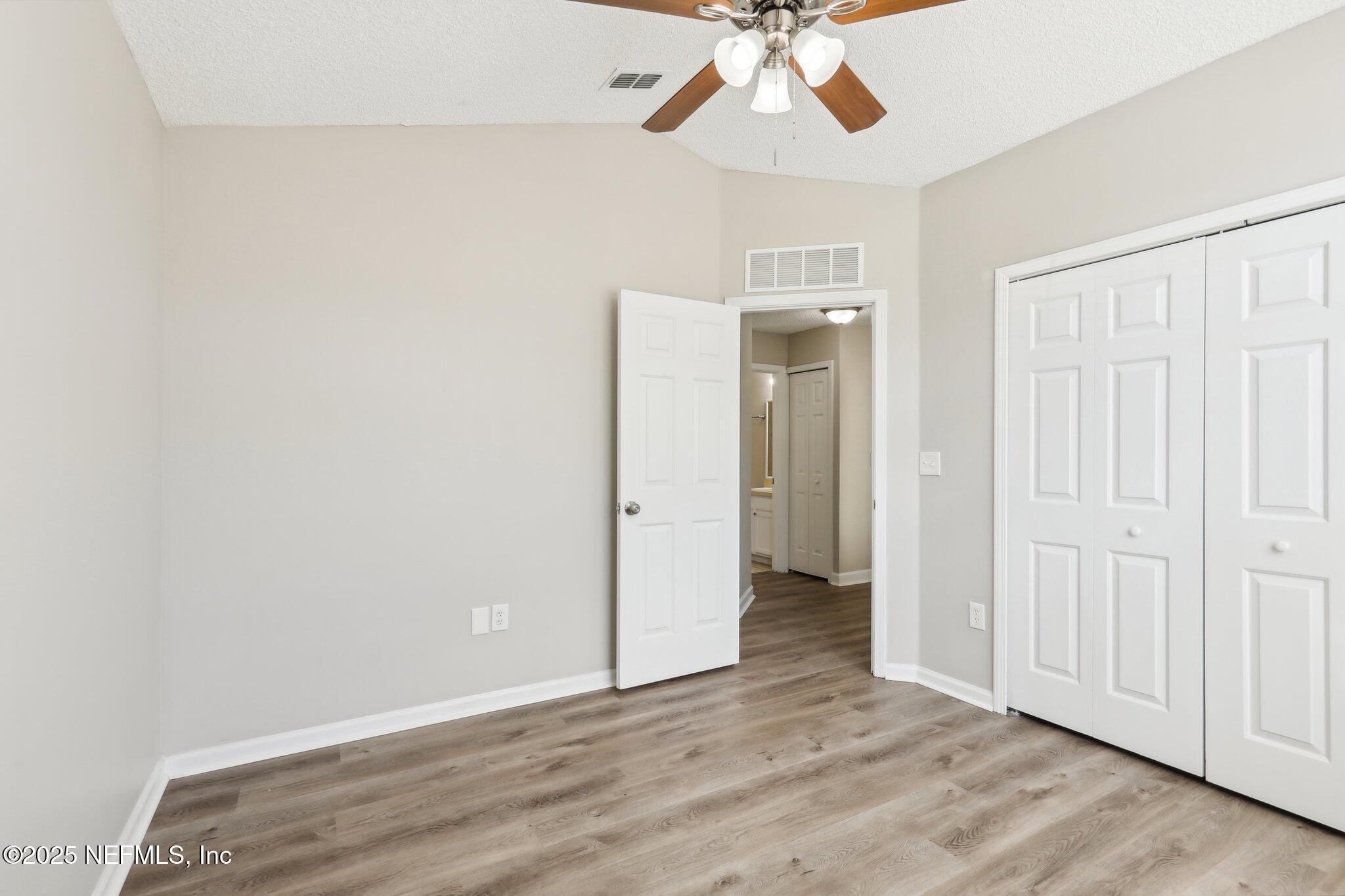 86123 Red Holly Place Yulee, FL 32097 - Photo 21 of 36 an empty room with wooden floor fan and windows