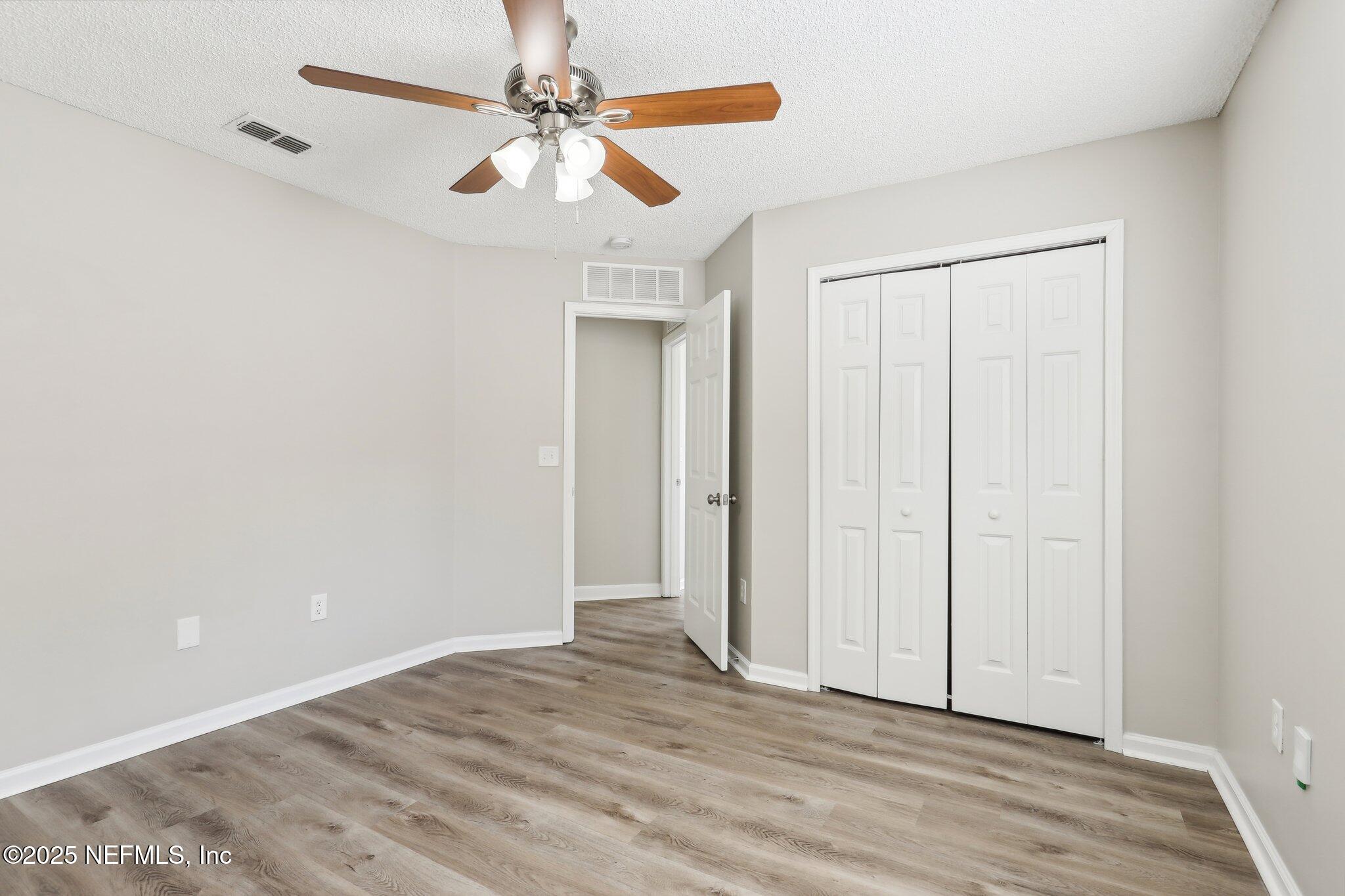 86123 Red Holly Place Yulee, FL 32097 - Photo 24 of 36 an empty room with wooden floor fan and windows