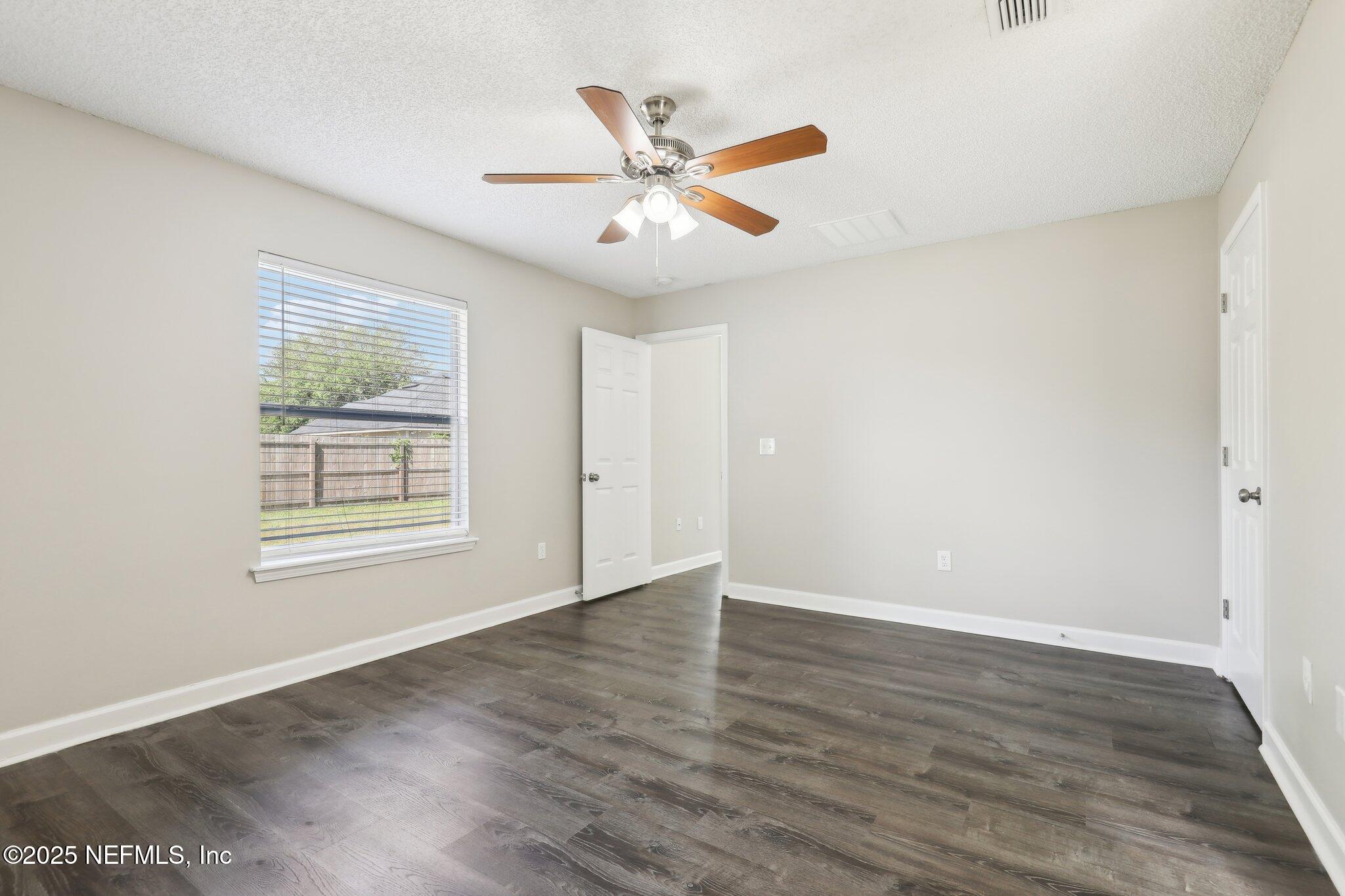 86123 Red Holly Place Yulee, FL 32097 - Photo 27 of 36 an empty room with wooden floor fan and windows
