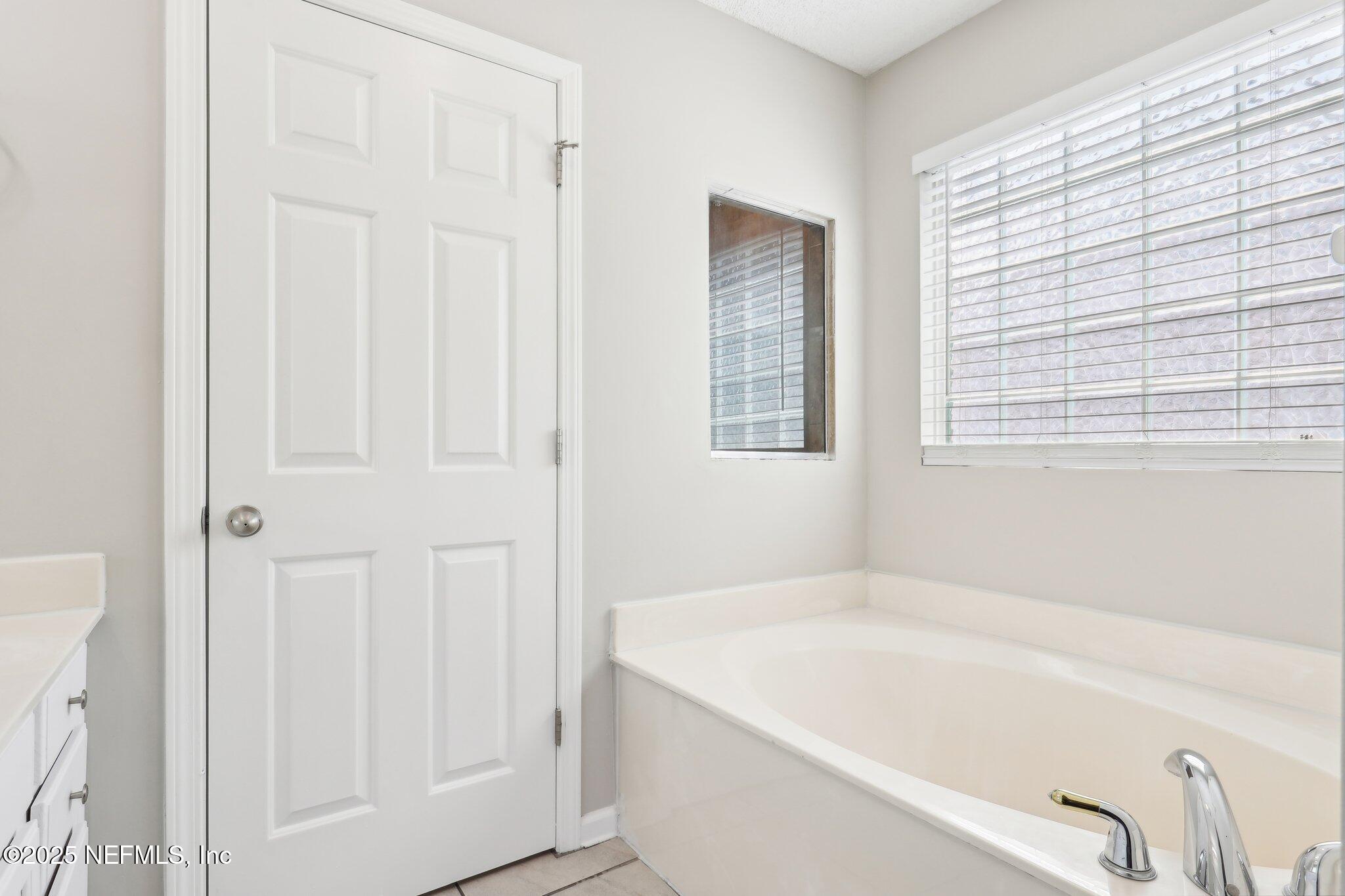 86123 Red Holly Place Yulee, FL 32097 - Photo 31 of 36 a bathroom with bathtub and a window