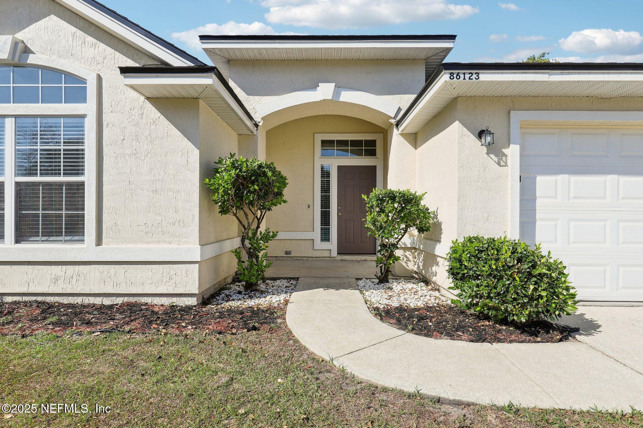 86123 Red Holly Place Yulee, FL 32097 - Photo 4 of 36 a front view of a house with garden