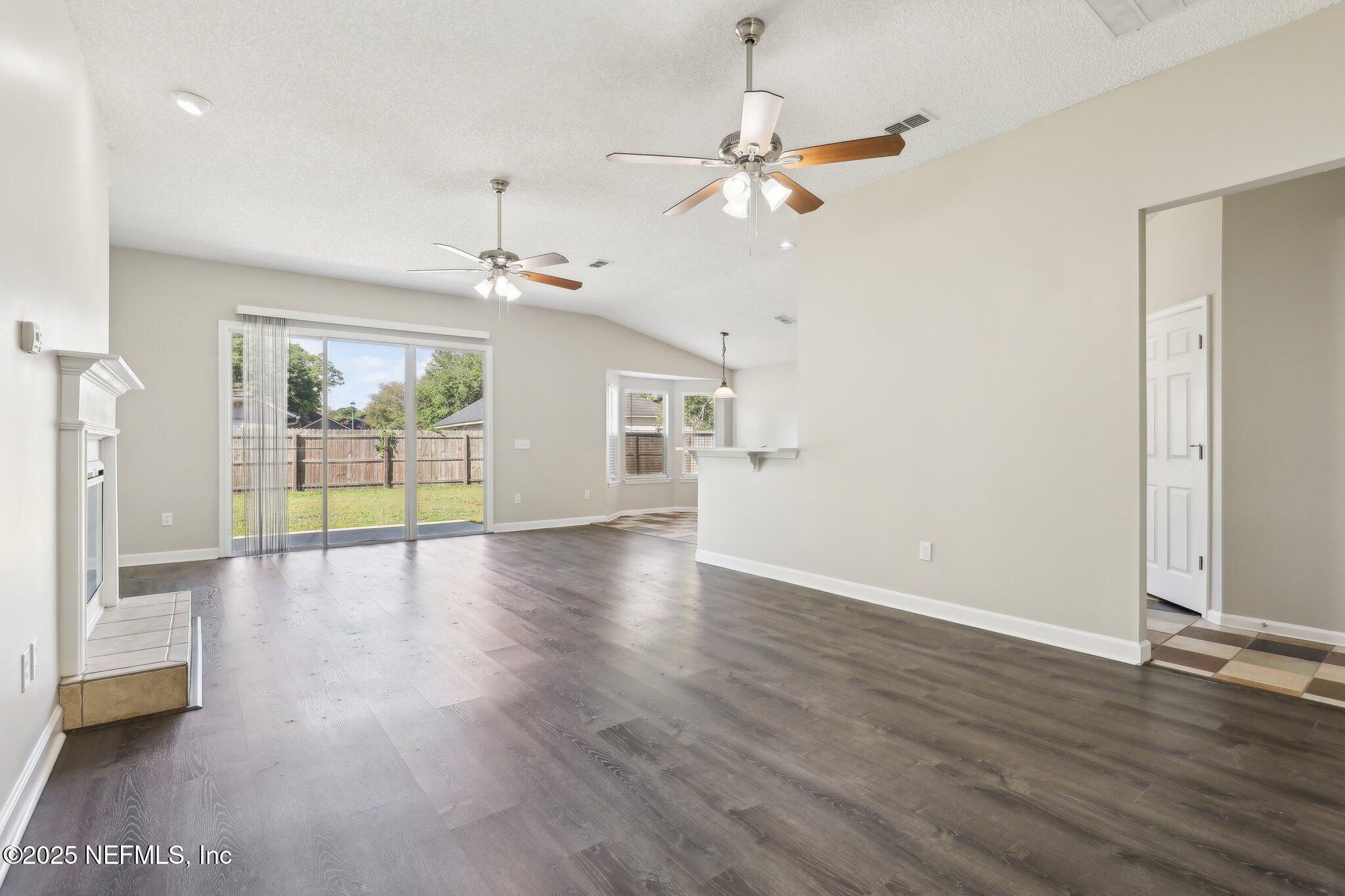 86123 Red Holly Place Yulee, FL 32097 - Photo 5 of 36 a view of an empty room with wooden floor and a window