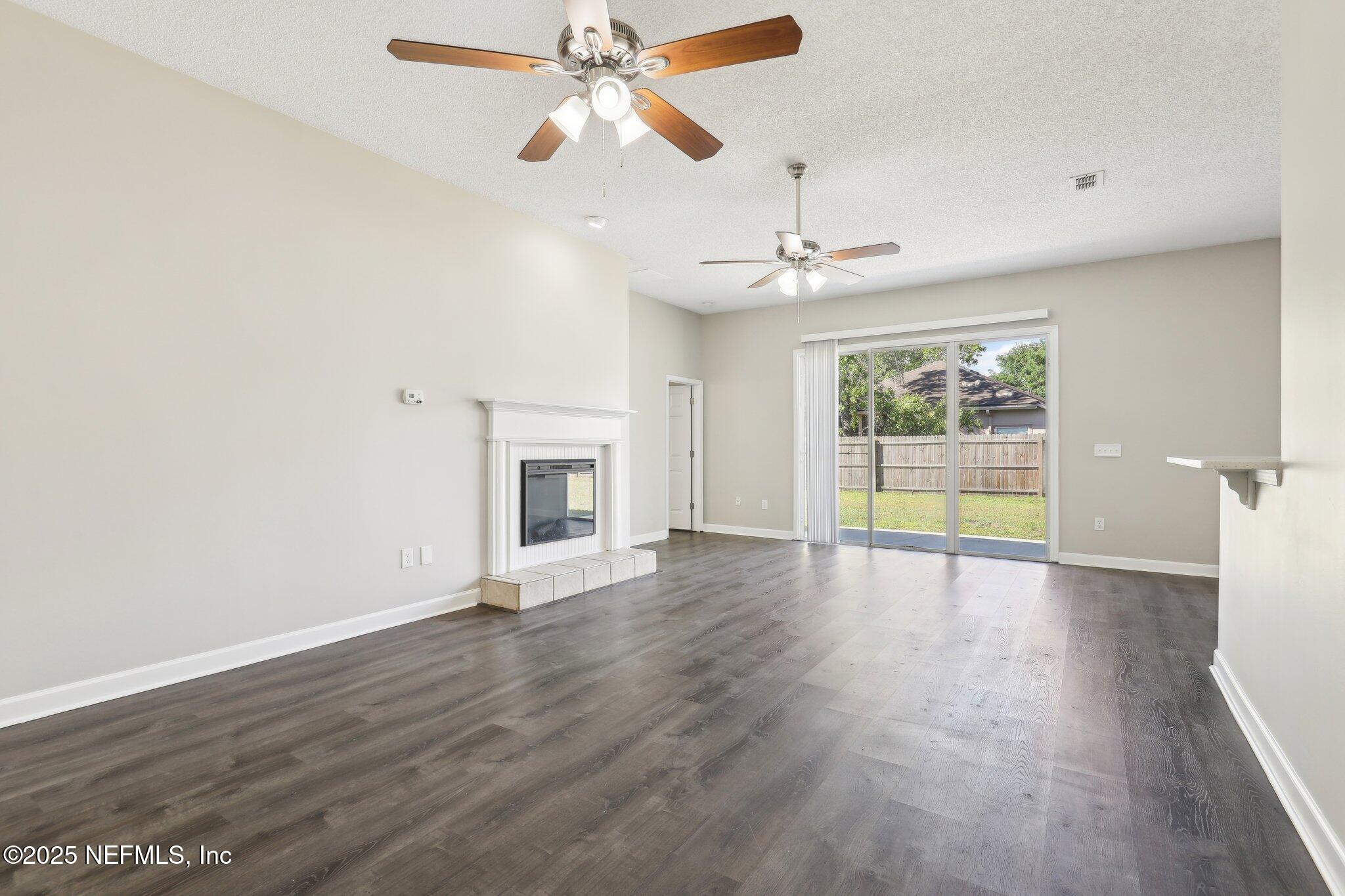 86123 Red Holly Place Yulee, FL 32097 - Photo 7 of 36 a view of an empty room with a fireplace and a window