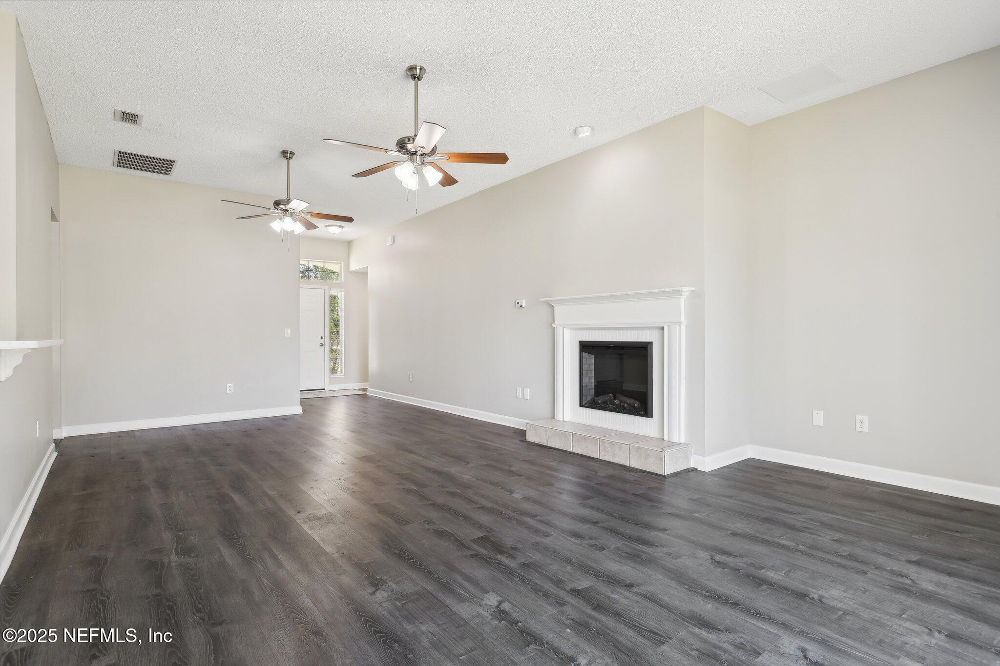 86123 Red Holly Place Yulee, FL 32097 - Photo 8 of 36 a view of an empty room with wooden floor and a fireplace