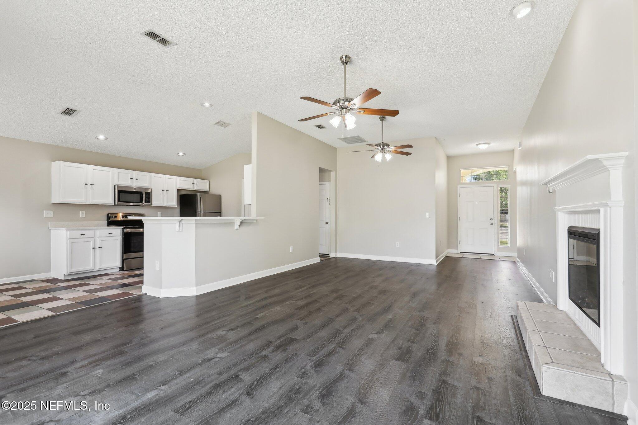 86123 Red Holly Place Yulee, FL 32097 - Photo 9 of 36 a view of a kitchen with stove and wooden floor