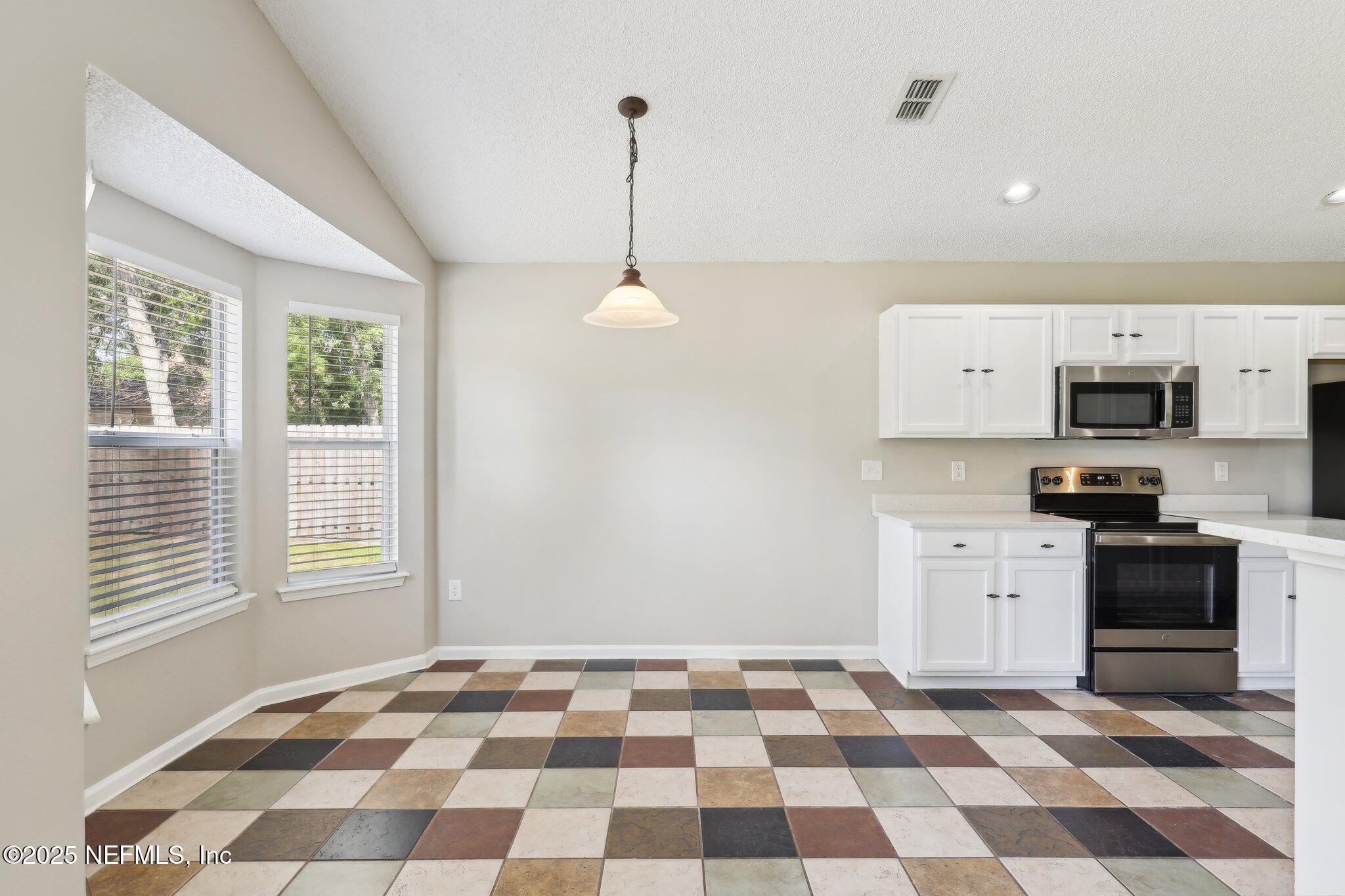86123 Red Holly Place Yulee, FL 32097 - Photo 10 of 36 a kitchen with stainless steel appliances granite countertop a sink and a stove