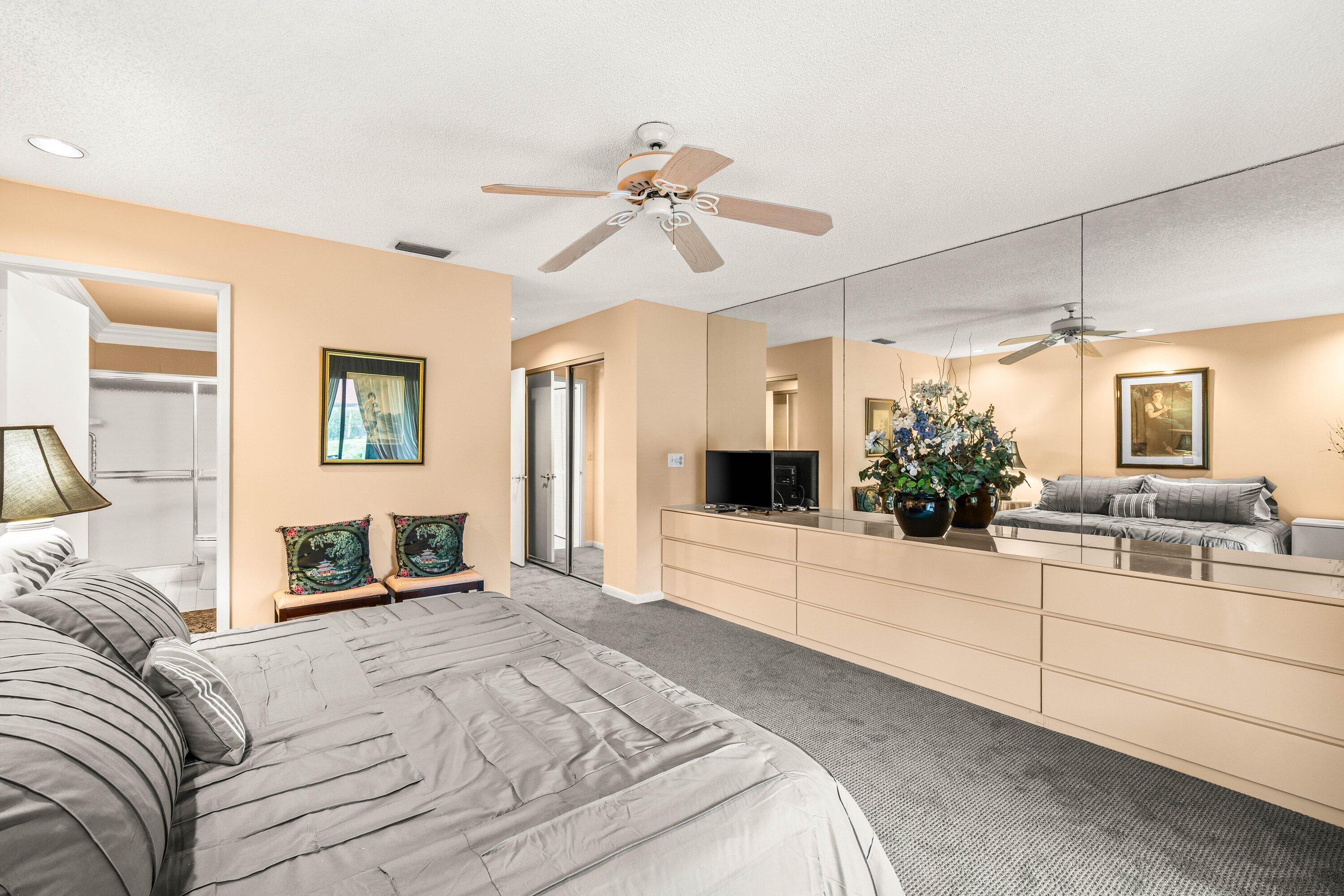 8191 Whispering Palm Drive Boca Raton, FL 33496 - Photo 18 of 34 a bedroom with a large bed and a flat screen tv